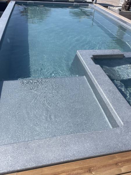 Modèle Manhattan: piscine rectangulaire avec spa à débordement intégré et plage immergée